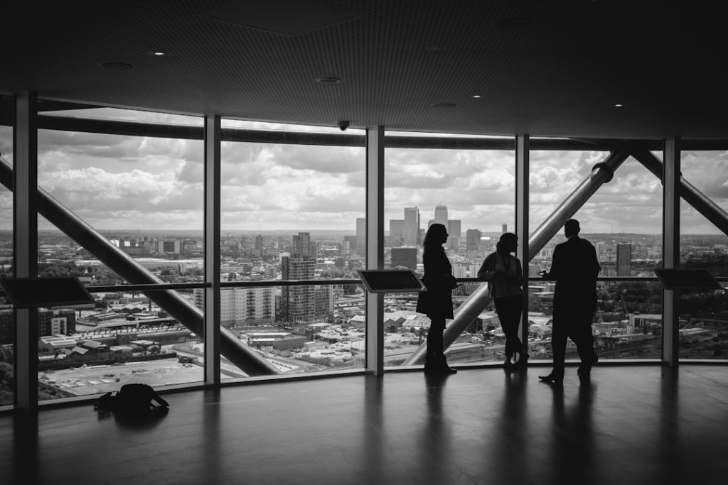 people-standing-inside-city-building-3fpxt37x6uq meeting near a transparent glass