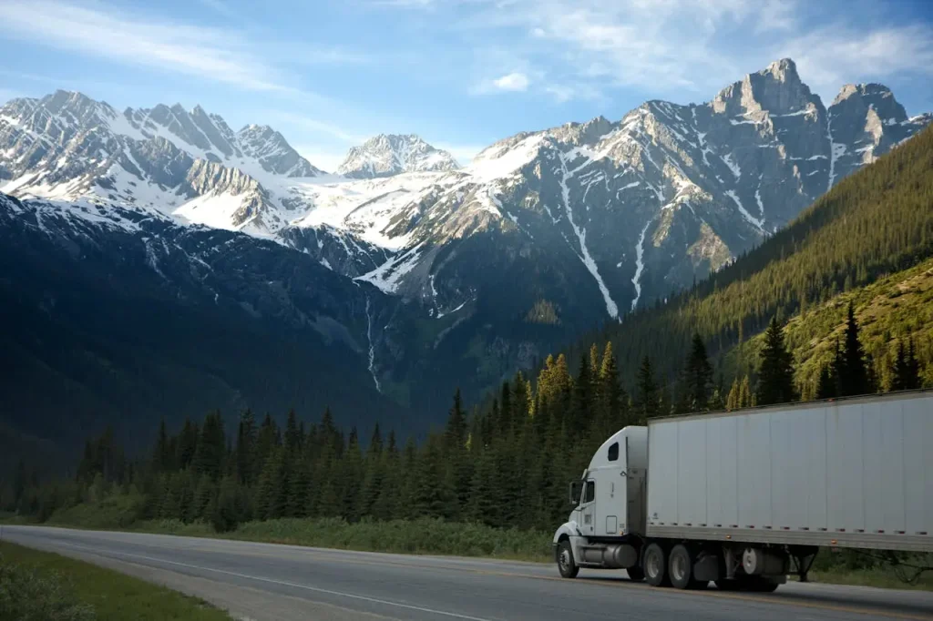white-dump-truck-near-pine-tress-during-daytime-93398